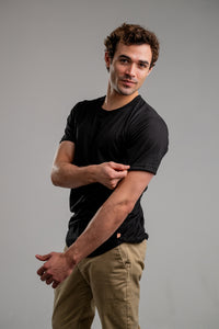 Man wearing UndrDog Midnight black men's hemp and bamboo T-shirt with fitted sleeves and curved hem.